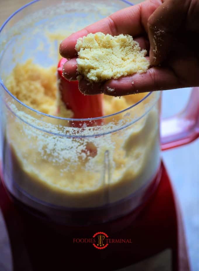 Soaked and pealed almonds grounded in mixer jar and shown by hands.