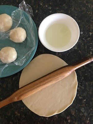 Rolling pin placed over a dough rolled to about 7-8 inch flat disk.