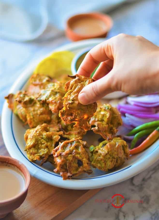 Chicken pakora recipe being lifted from the plate