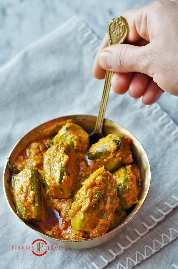 Potol Korma or Parwal Korma served in a brass bowl with a spoon