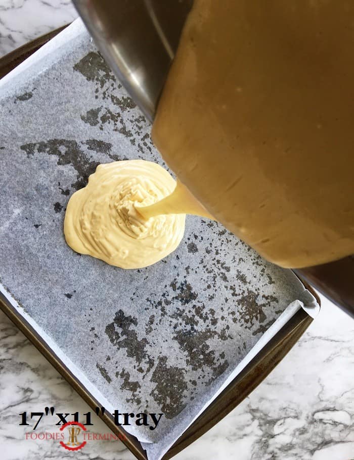 Cake batter being poured on a 17 x 11 inch pan