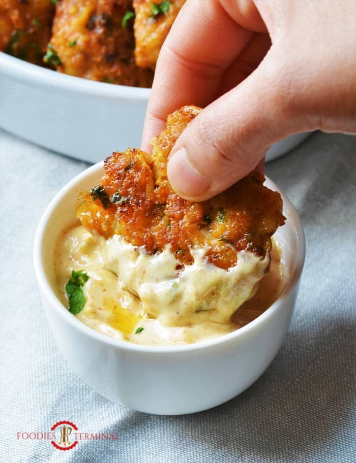 Shrimp cake being dipped in Aioli