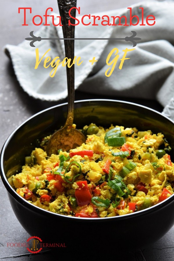 Tofu scramble served in a black bowl with a spoon