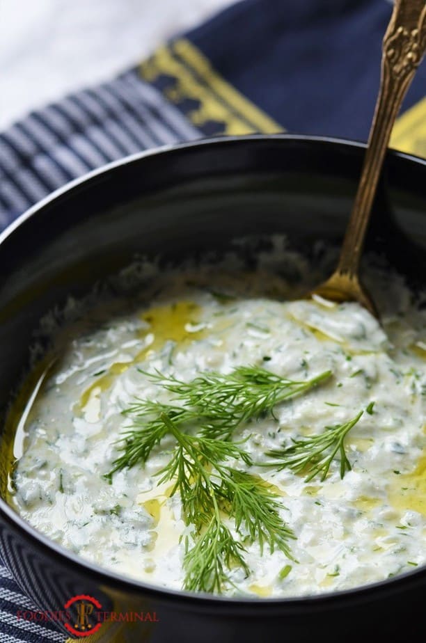 Best Tzatziki Sauce Recipe garnished with dill in a black bowl