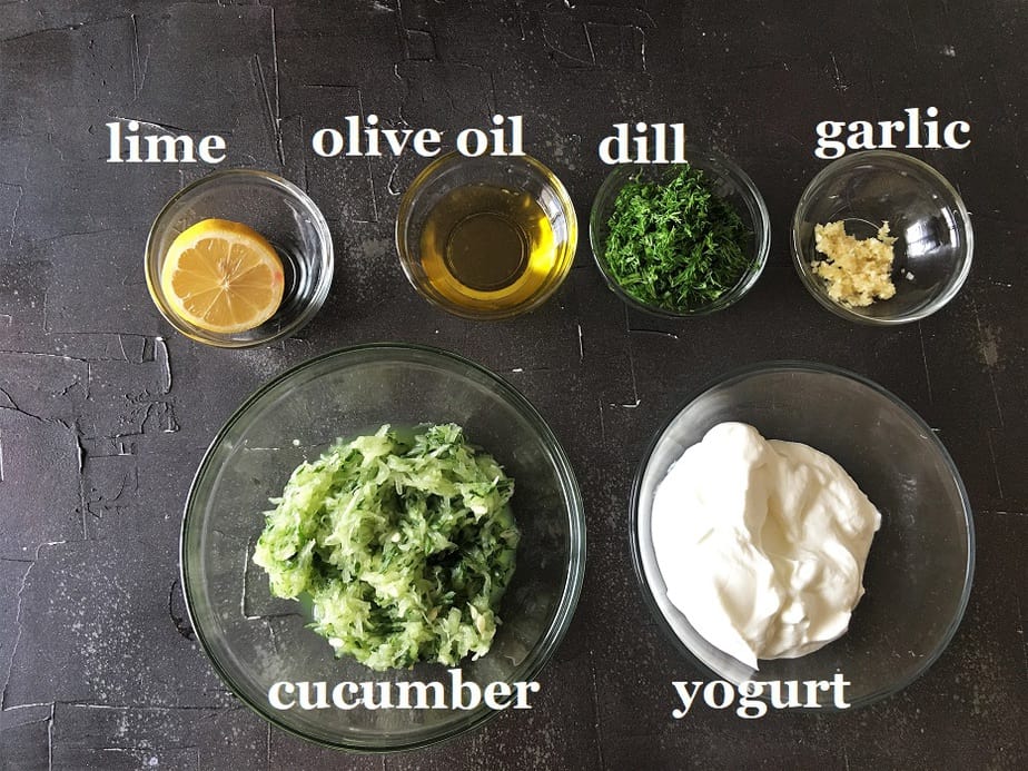 Tzatziki Ingredients in various size round bowls on a black surface
