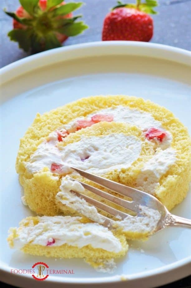 Vanilla Swiss Roll cake slice being eaten with a fork