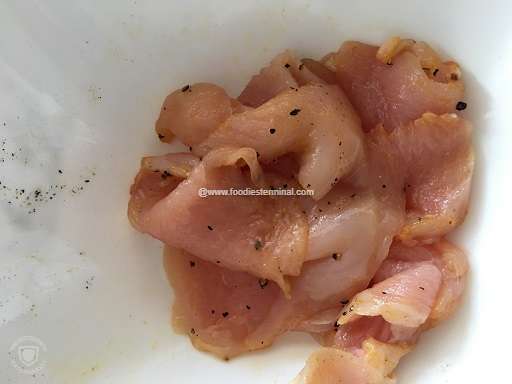 Marinated chicken breasts in a white bowl