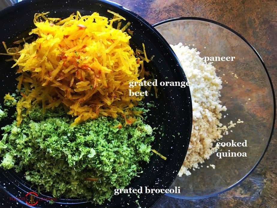 Quinoa patties ingredients grated broccoli & grated orange beet on a black plate