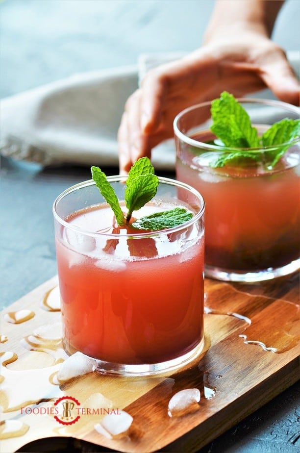 Kokam Sherbet served in two transparent glasses kept on a wooden board