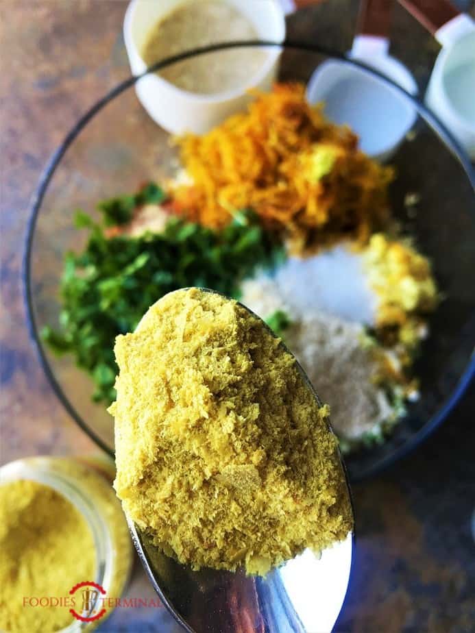 Nutritional yeast being added to the dough of quinoa paneer cutlets