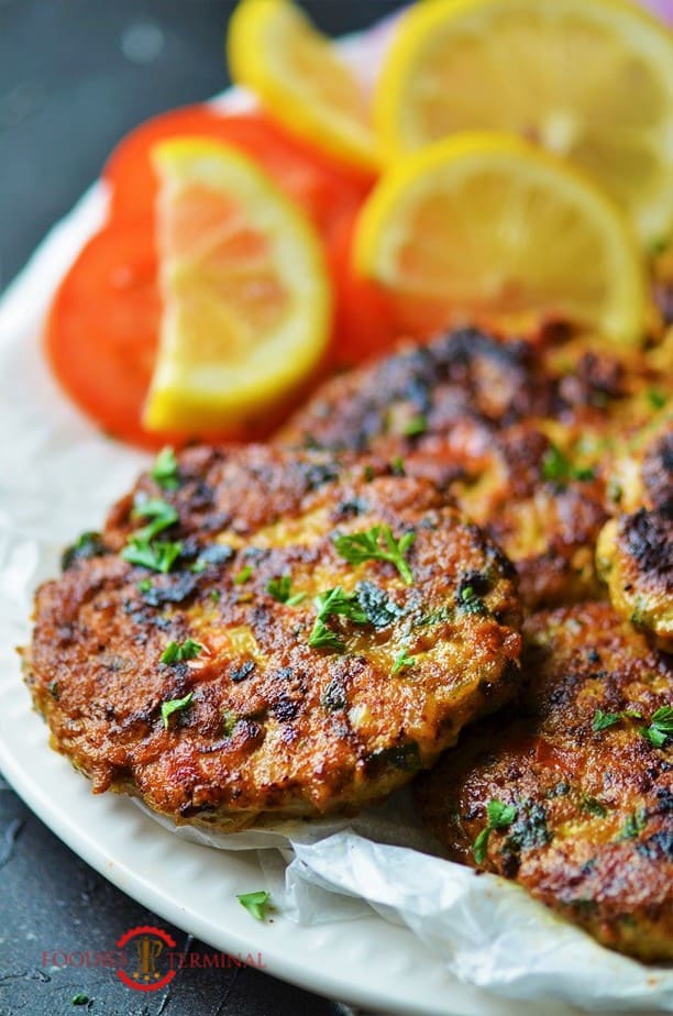 chicken chapli kabab on a white plate garnished with cilantro