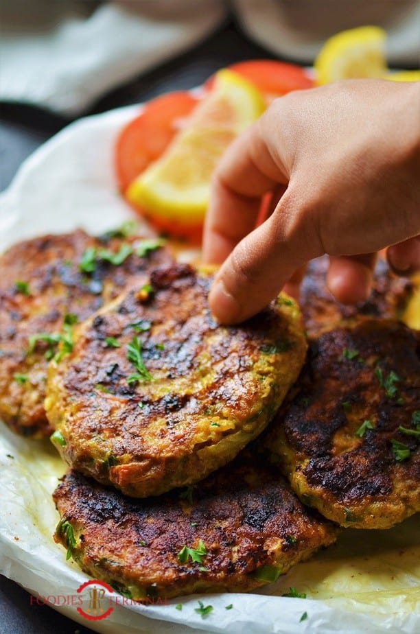 Chicken Chapli Kabab stacked together & being lifted