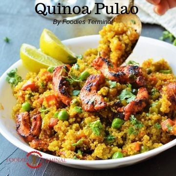 Quinoa Pulao served in a white bowl with lemon wedges