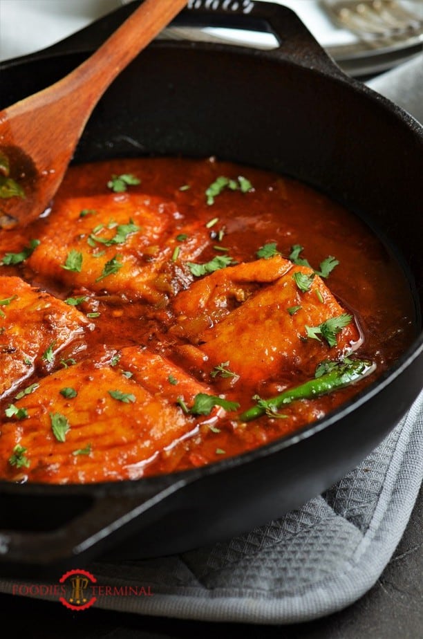 Indian style Salmon curry garnishe with cilantro in a black wok