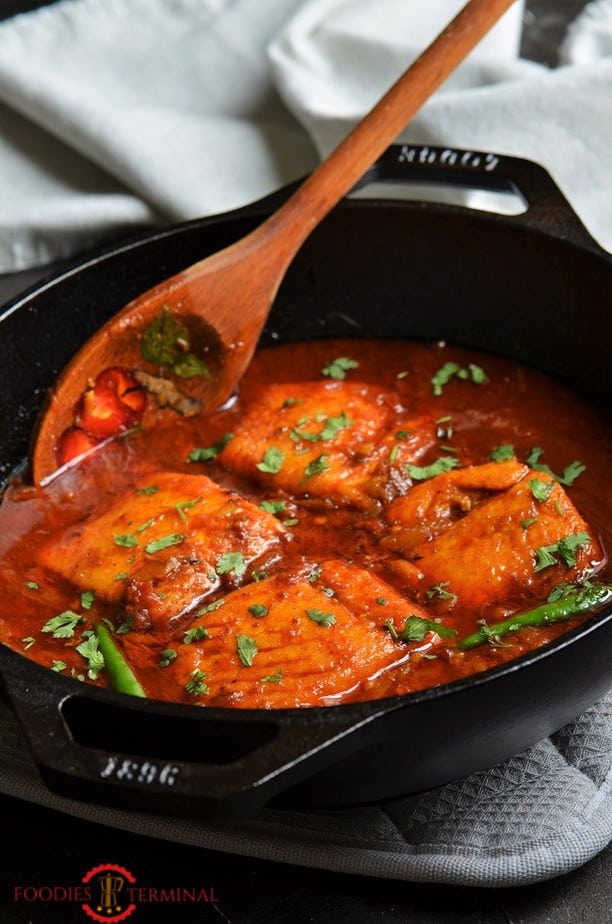 Indian Salmon Curry in a wok with a wooden spatula 