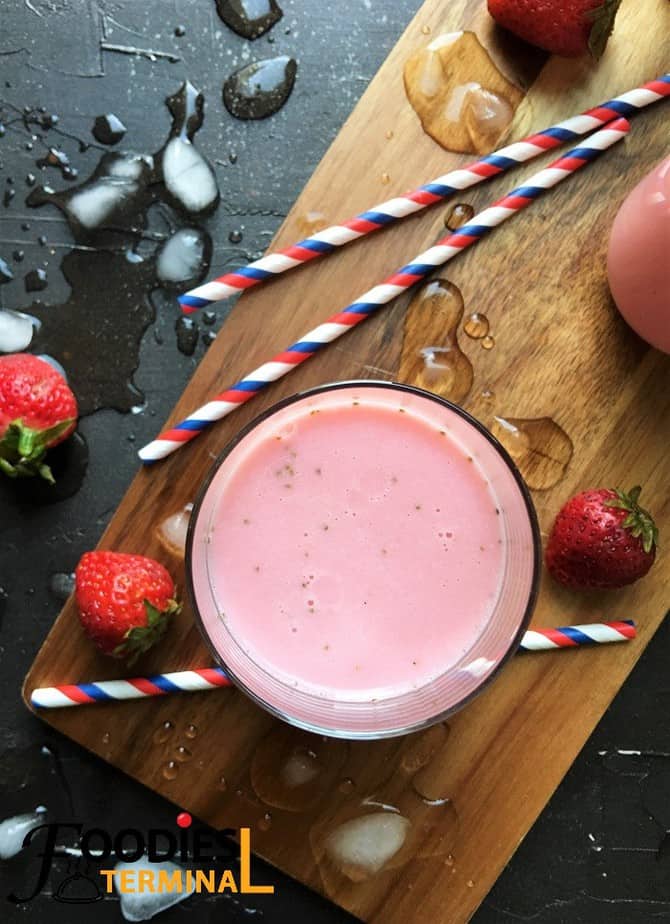 Homemade strawberry lassi recipe with berries by the side