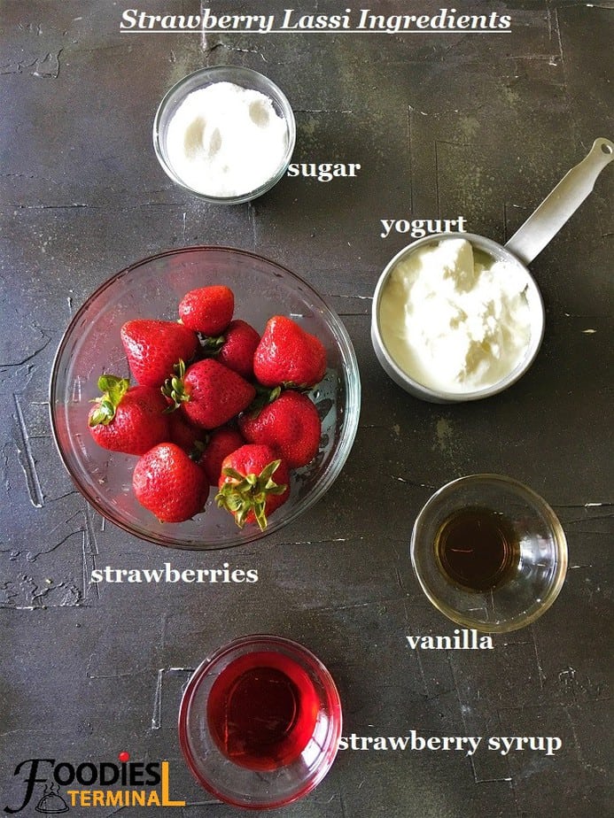 Homemade Indian style strawberry lassi ingredients in bowls