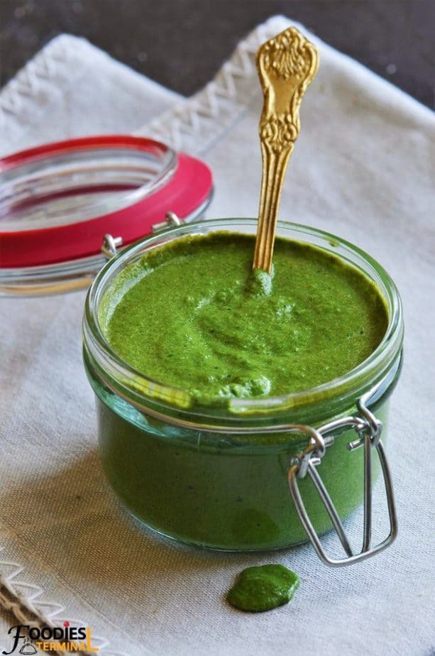 Pudina chutney gorgeous green color in a pot with a brass spoon