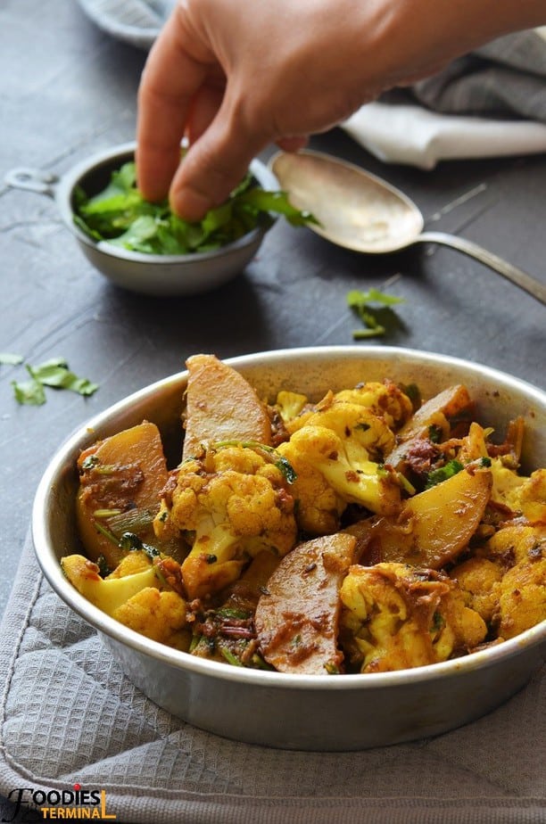 Indian cauliflower sabzi served with cilantro in a tiny bowl