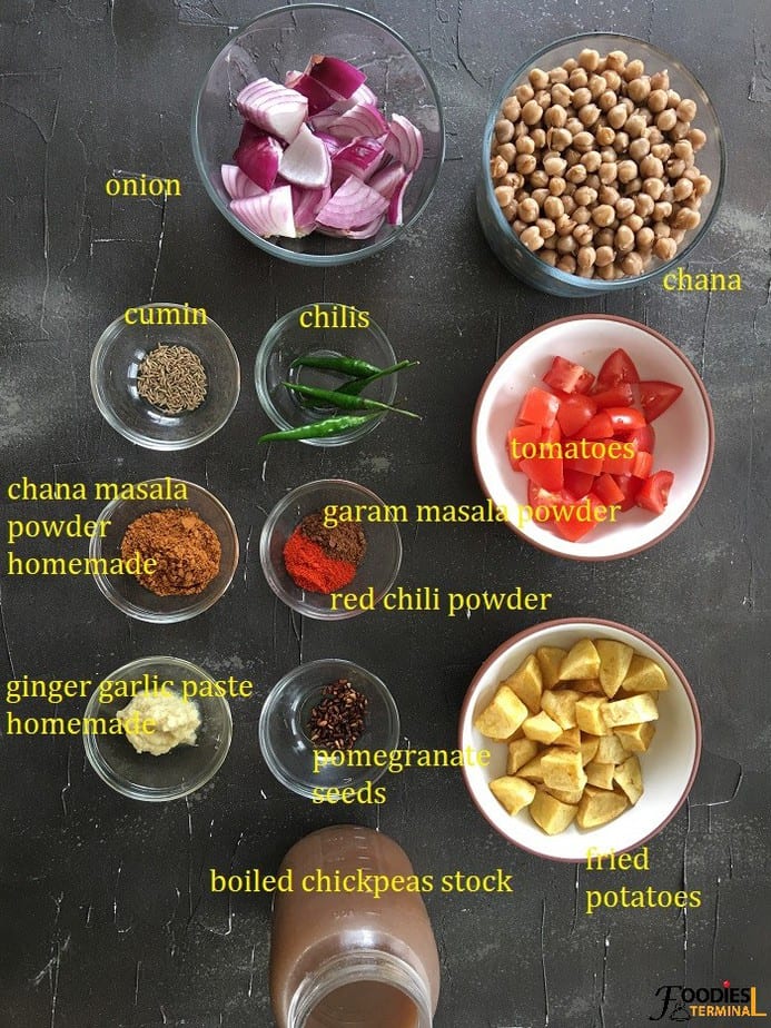 aloo chole ingredients kept in bowls on a black surface