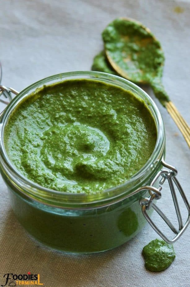 Pudina ki chutney in a glass jar with a poon by the side