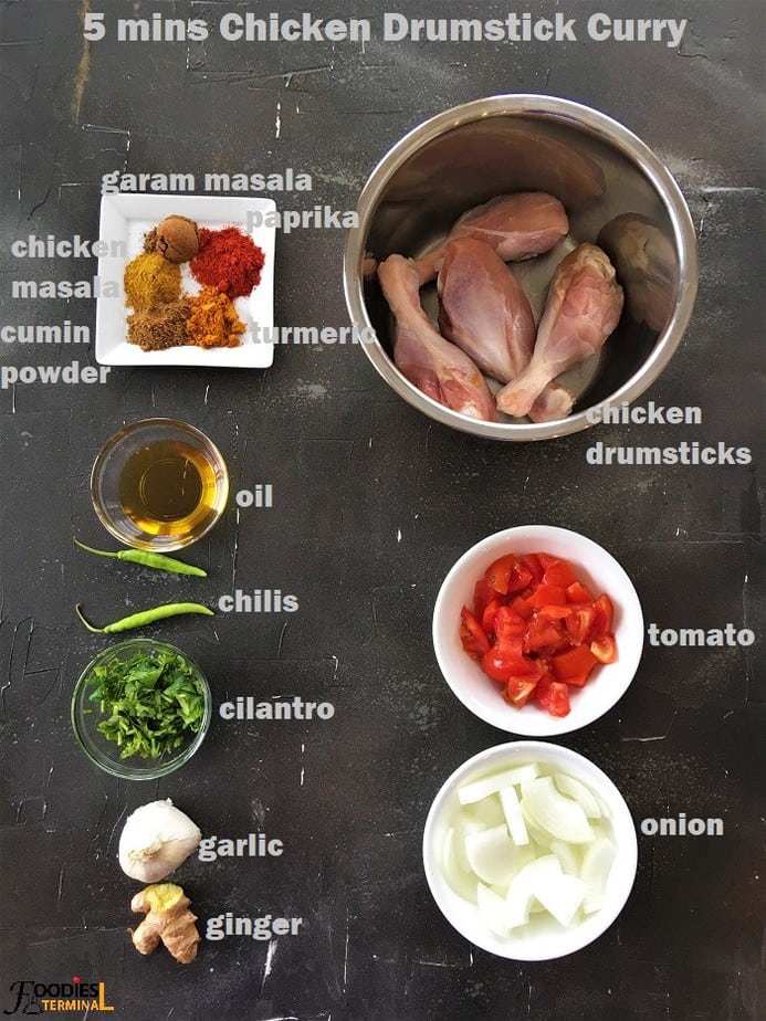 chicken drumstcick curry ingredients in bowls on a black surface