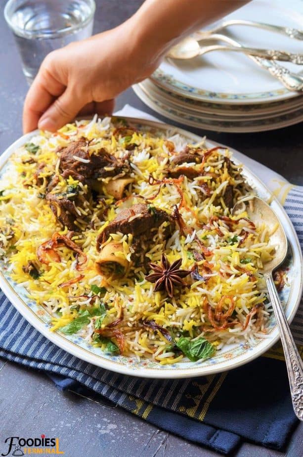 Homemade Mutton Biryani in an oval plate with mutton pieces & birista