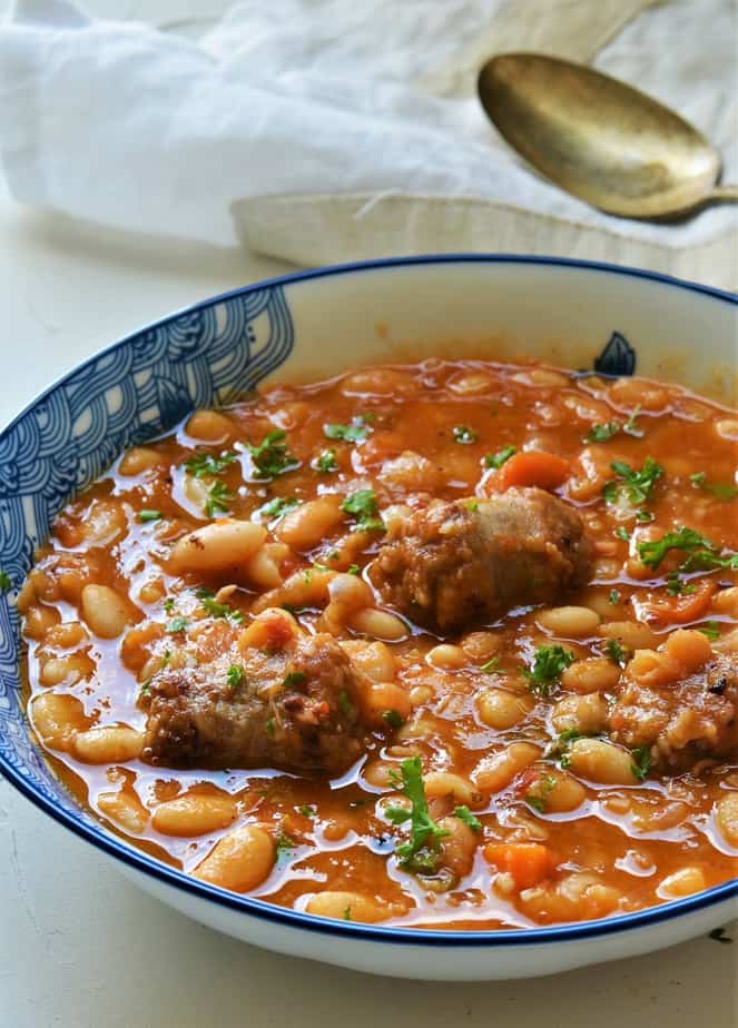 Herbed White Bean and Sausage Stew in a bowl with blue prints