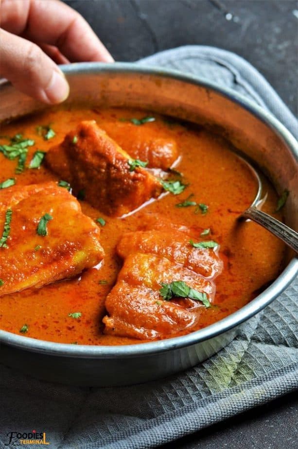catfish curry in an aluminum plate with a spoon