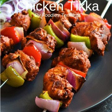 Chicken tikka in metal skewers with veggies