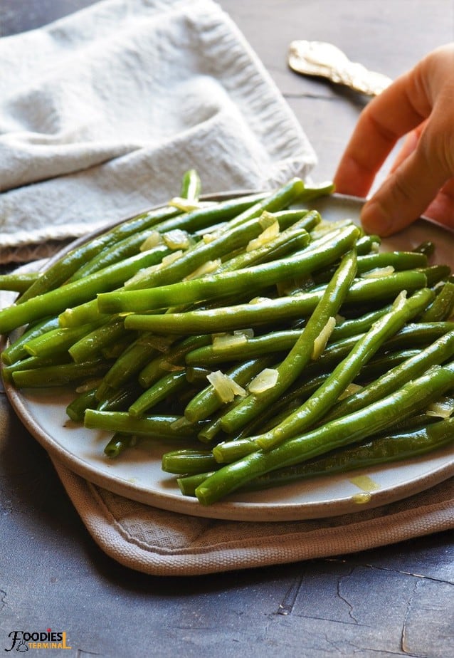 Instant Pot green beans seasoned with onion garlic served on a plate