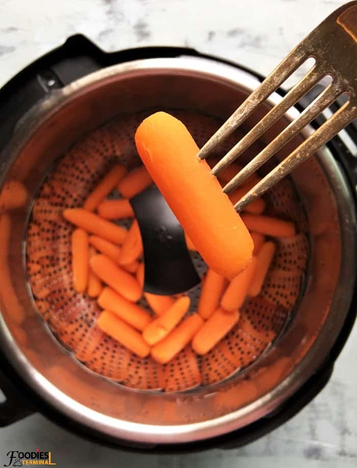 Instant pot steamed baby carrots picked with a fork 