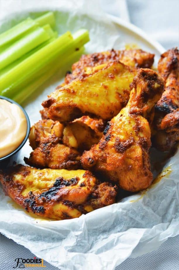 Tandoori wings served in a basket with sauce.