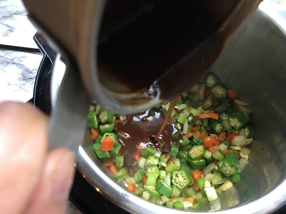 pouring dark roux over the veggies in instant pot