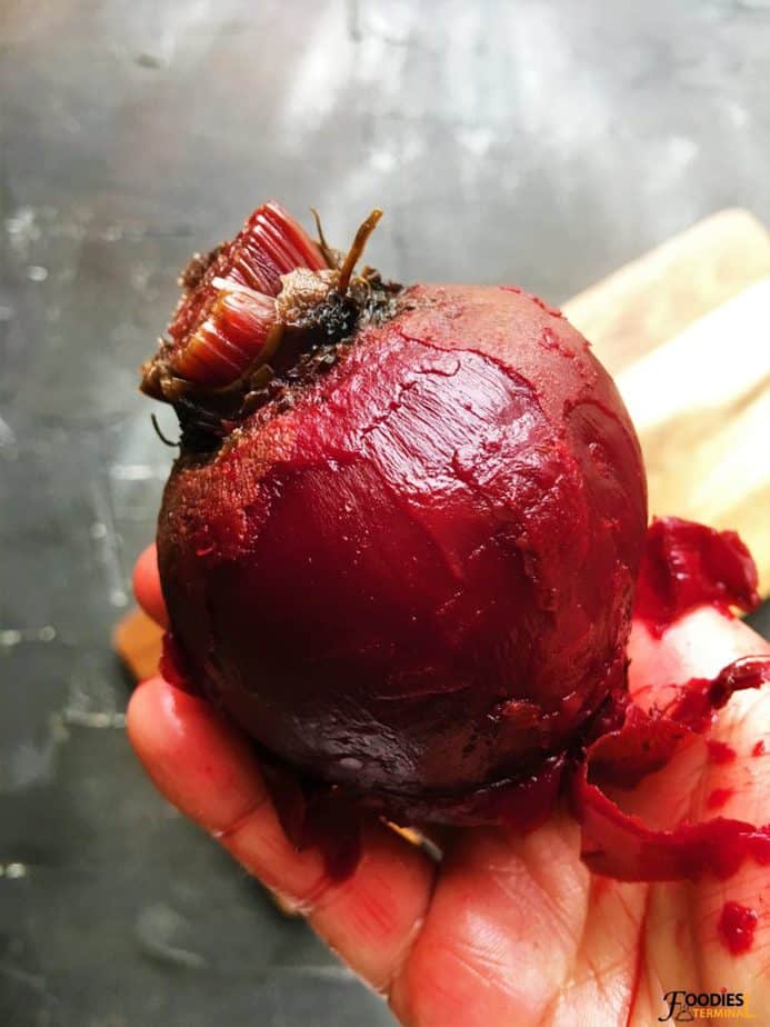 peeling cooked beets skin with hand