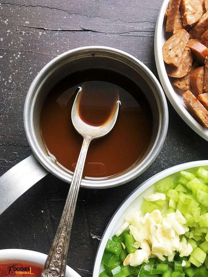 Gumbo roux recipe in an aluminum saucepan with a spoon