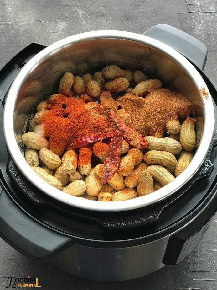 Raw peanuts with seasonings inside the instant pot ready for boiling