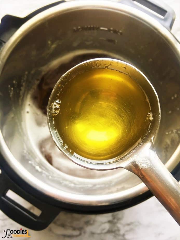 Instant pot golden ghee ready in a ladle