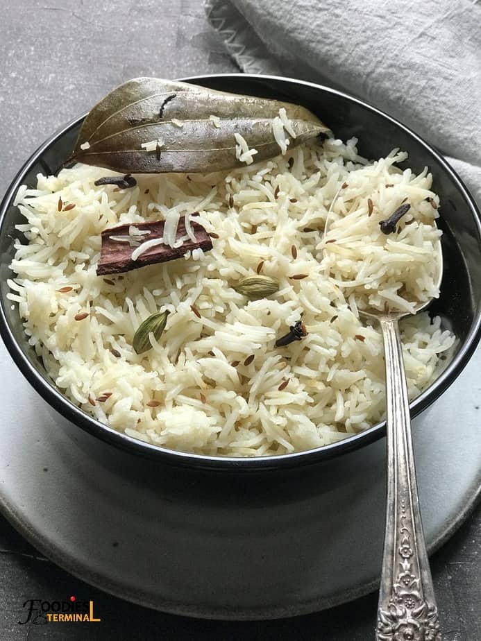 Jeera Rice Instant Pot in a black bowl with a spoon 