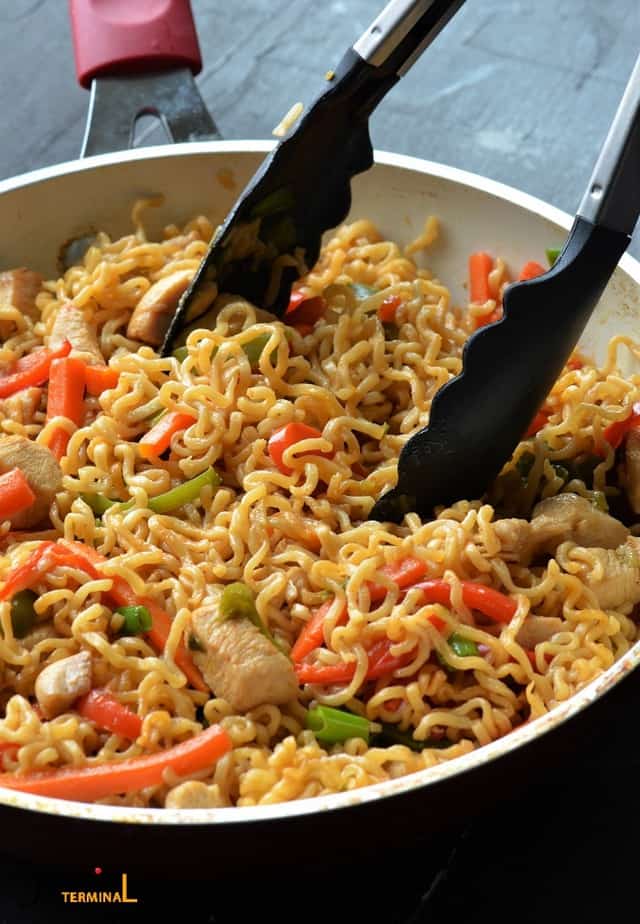 ramen stir fry with veggies & chicken in a pan with tong