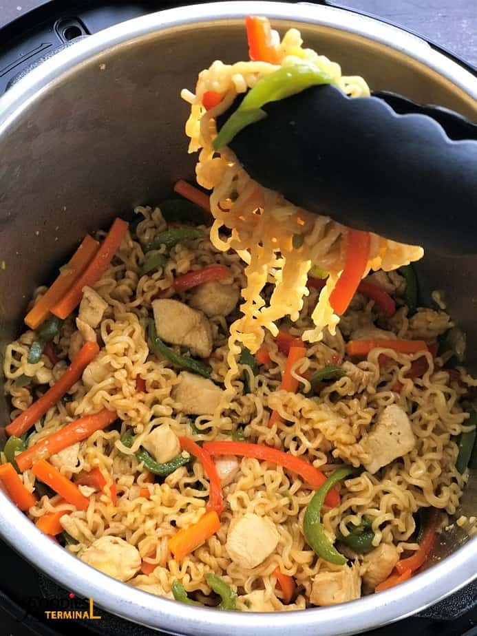 instant pot chicken ramen stir fry lifted with a tong
