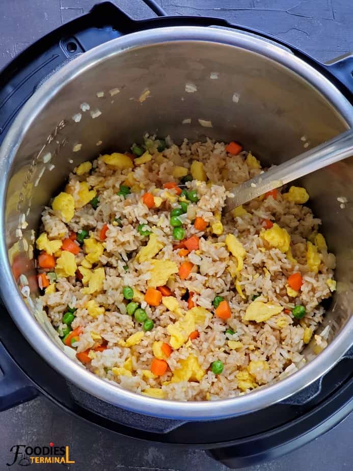 Instant Pot hibachi fried rice ready in the pressure cooker with a ladle tucked in