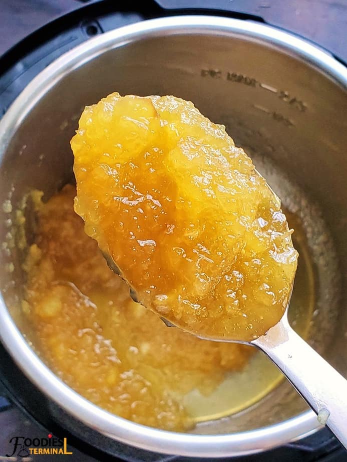 homemade pineapple jam in a ladle scooped from instant pot