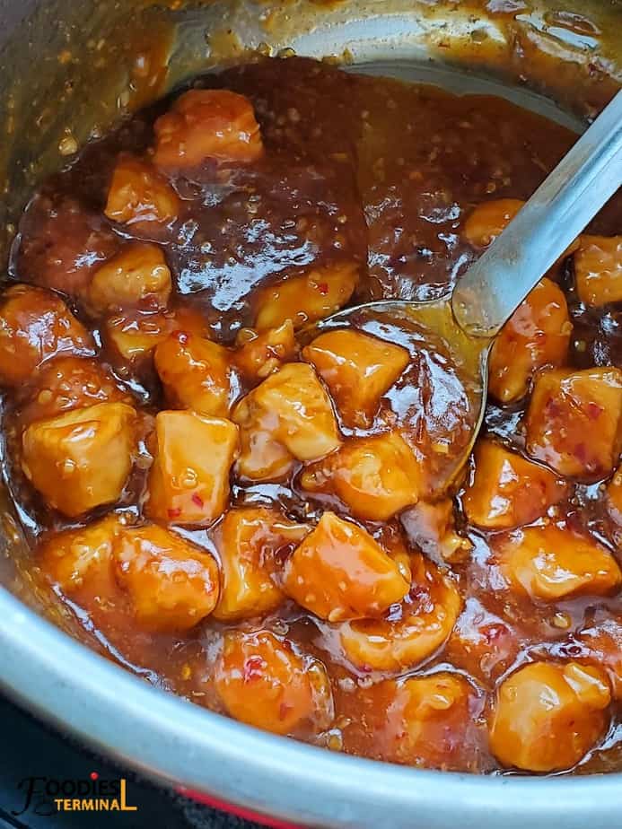 Healthy Orange Chicken inside Instant Pot with a steel ladle