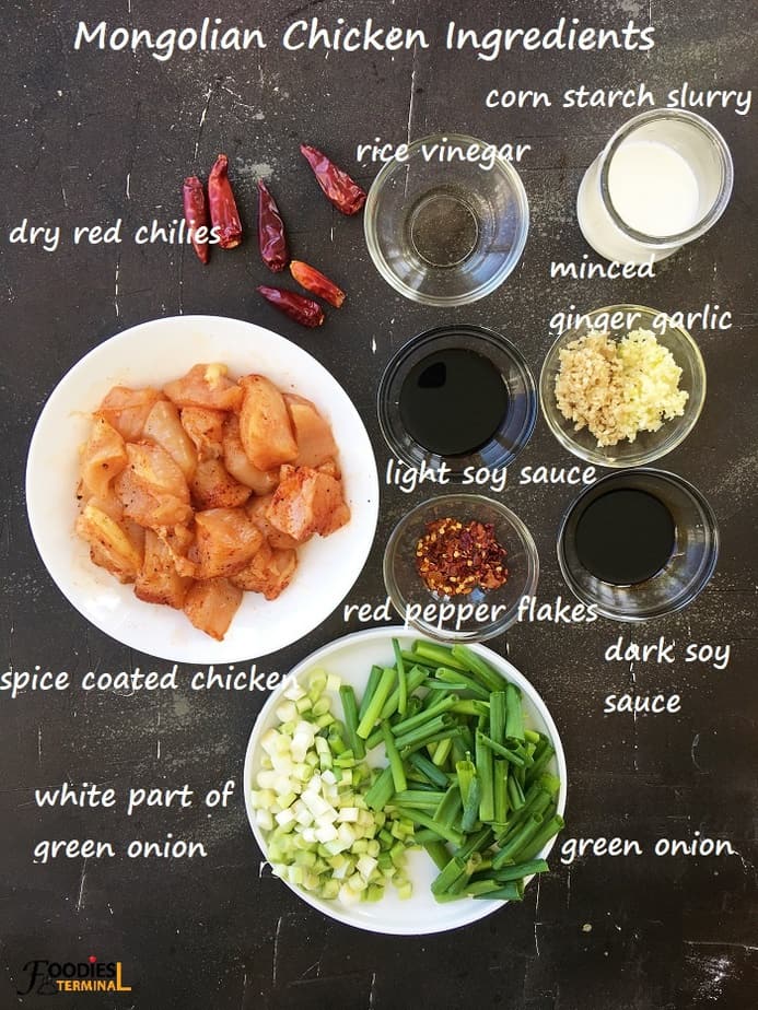 Mongolian chicken ingredients on small bowls on a black surface