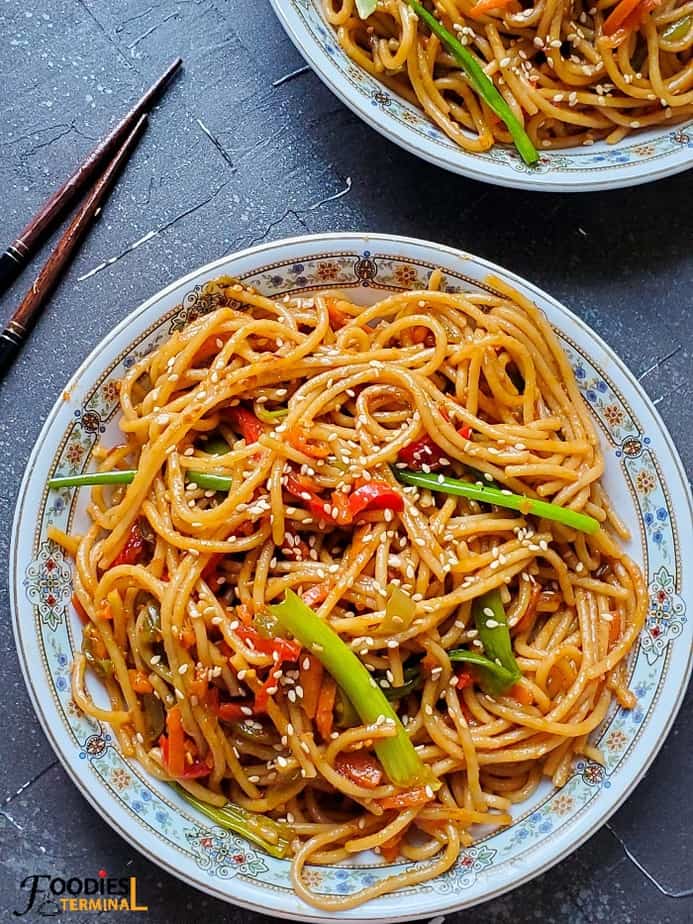 Chili garlic noodles instant pot on a white plate with chopsticks beside
