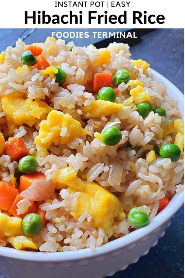 Hibachi Fried rice with scrambled egg, green peas, cubed carrots, jasmine rice in a white bowl