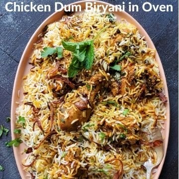Chicken Dum Biryani in an oval plate garnished with mint