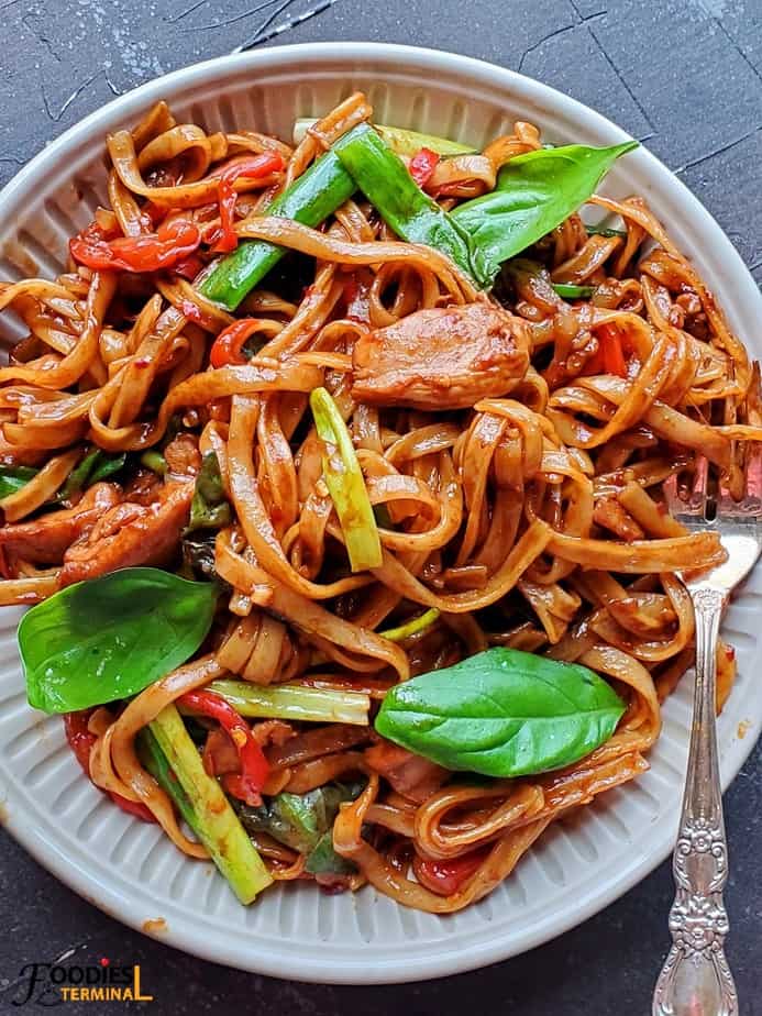 instant pot drunken noodles in a beige plate with a silver fork