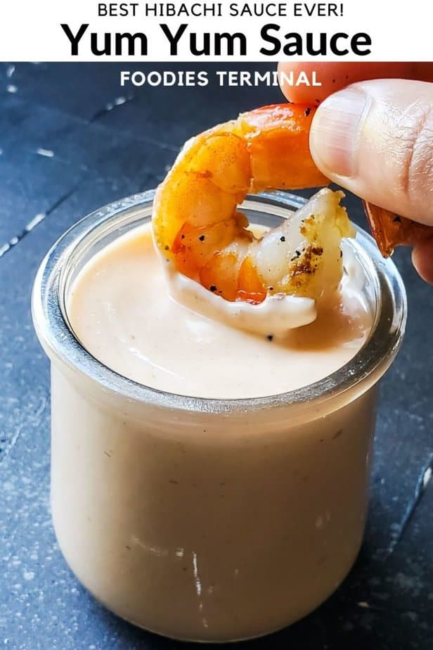 dipping a shrimp in yum yum sauce without tomato paste in a transparent glass jar
